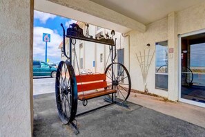 A vintage carriage parked outside a building with a clear sky in the background.
