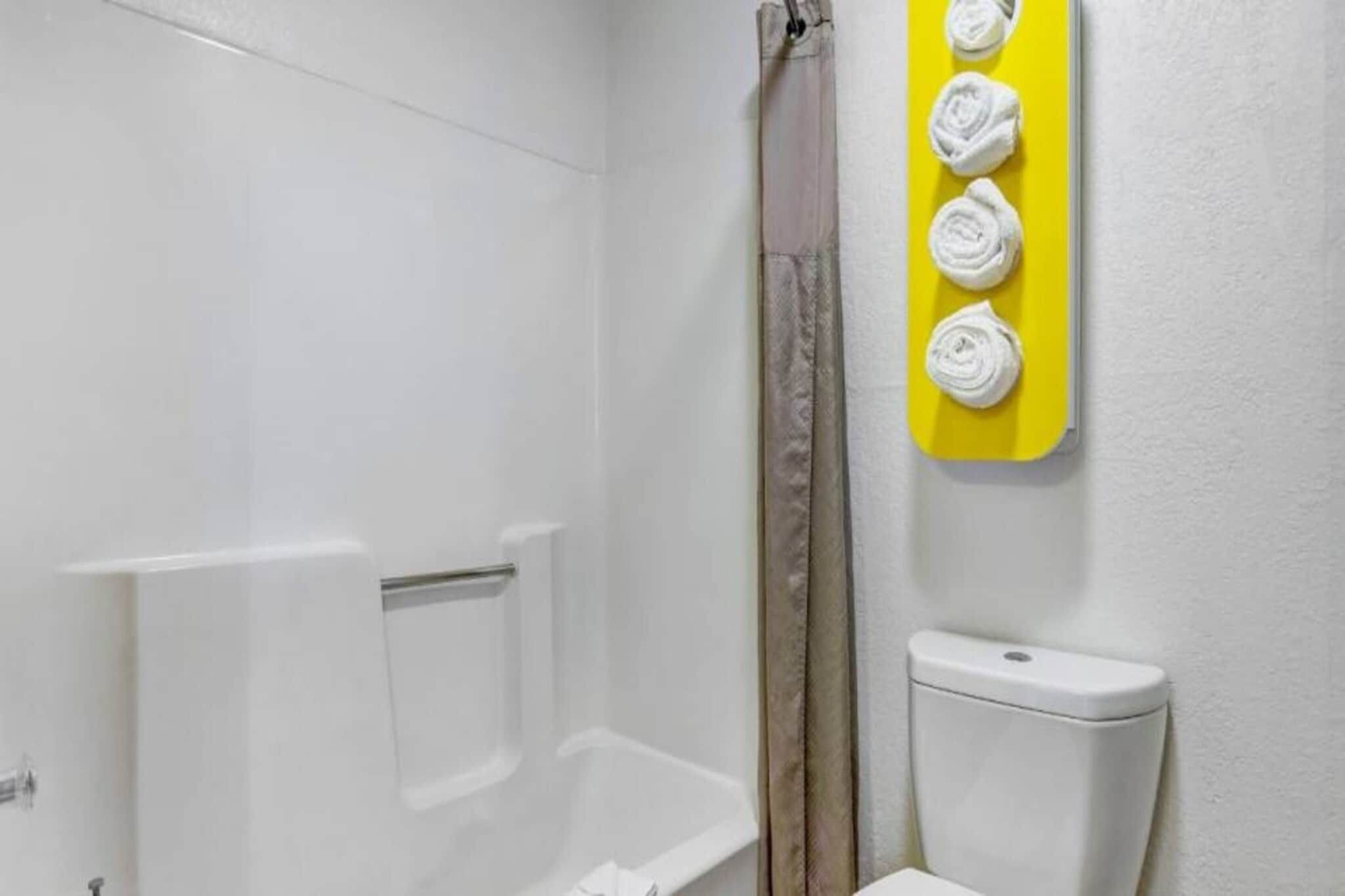 Un baño con una bañera blanca, un cortinero de ducha y un inodoro.