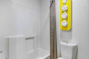 A bathroom with a white bathtub, a shower curtain, and a toilet. - 2 Queen Beds | Non-Smoking, Micfridge (Moriarty)