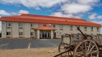 A building with a red roof, a covered entrance, and a parking lot.