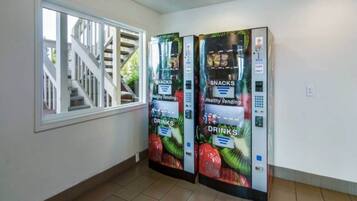 Corredor com duas máquinas de venda automática identificadas como 'Healthy Vending', para lanches e bebidas.