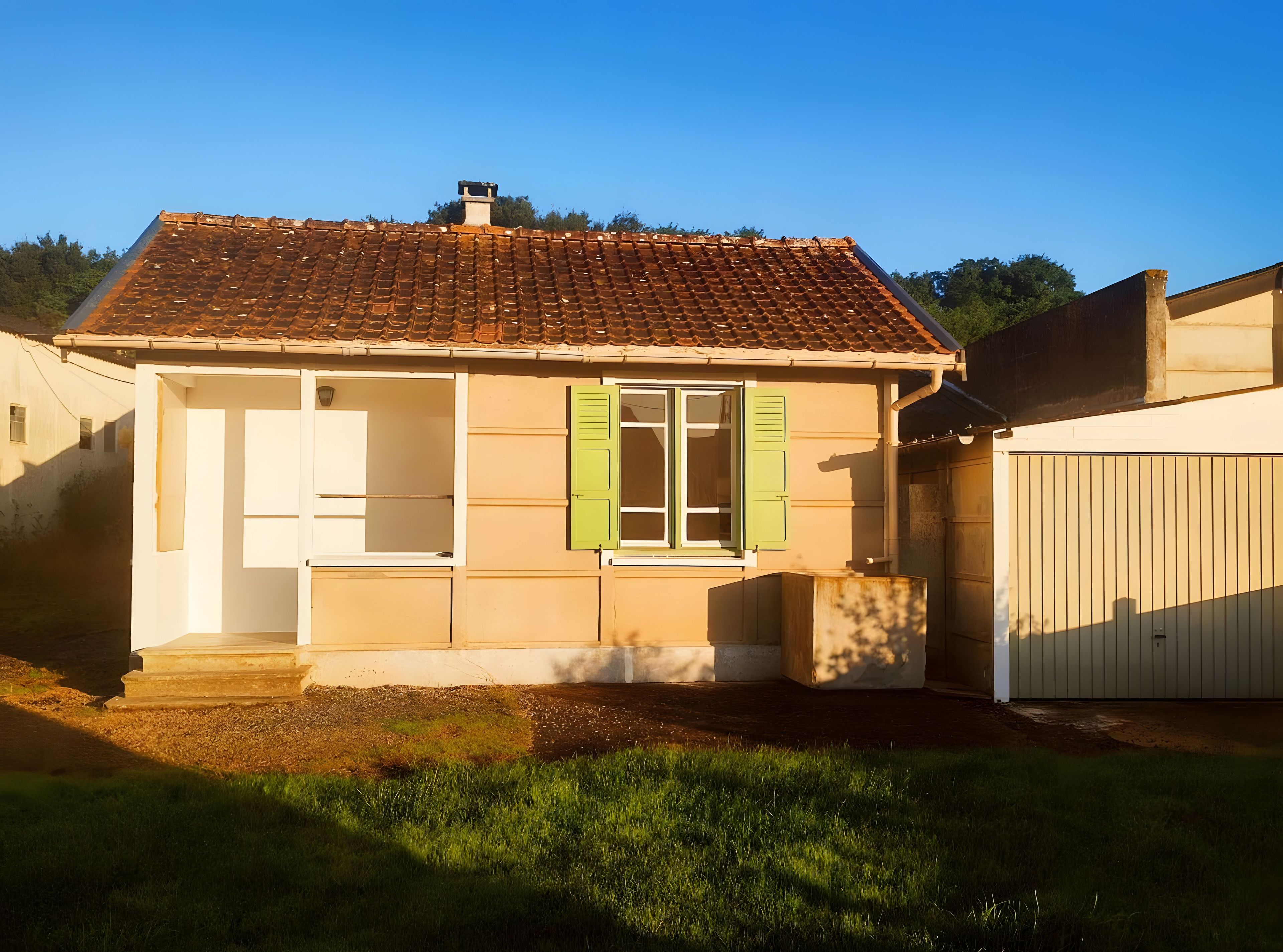 Une maison de plain-pied avec un toit en tuiles, une porte d’entrée et une fenêtre avec des volets.