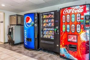 Máquinas de venda automática com logotipos Pepsi e Coca-Cola, e um micro-ondas.