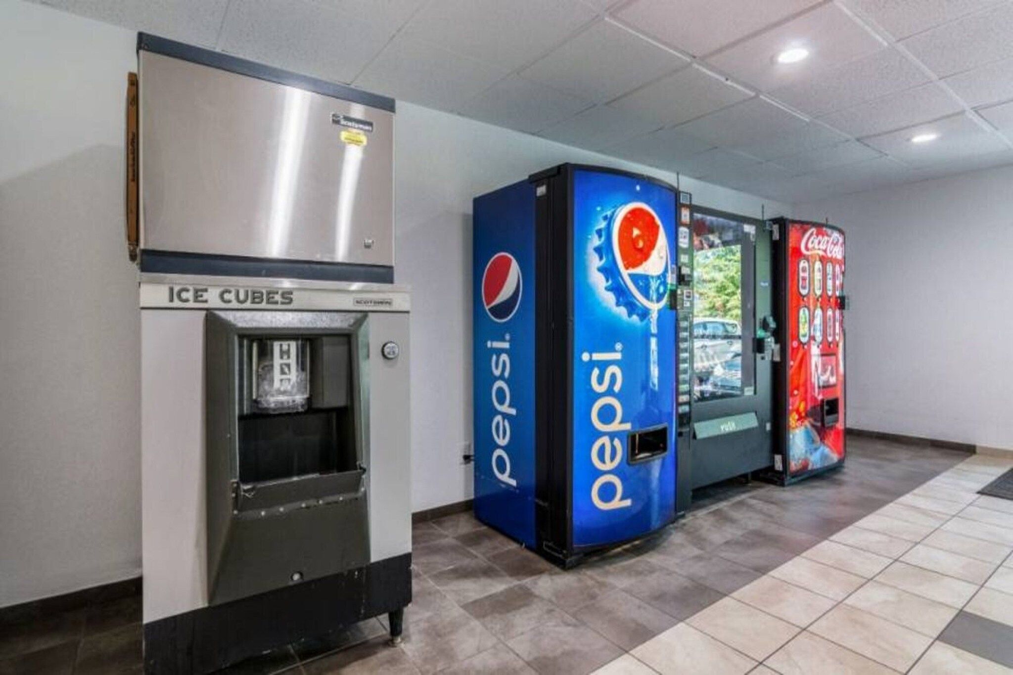 Automatische verkoopapparaten voor Pepsi en Coca-Cola, en een ijsmachine.