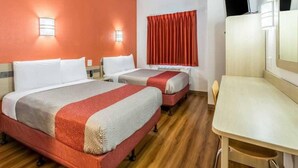 Una habitación de hotel con dos camas, un escritorio y una televisión.