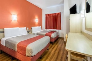Quarto de hotel com duas camas, uma escrivaninha e uma televisão.