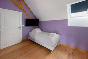 A bedroom with a bed, a television mounted on the wall, and a window. - Vacation Home “La Ramellerie - Grange Arthuis” with Wi-Fi and Air Conditioning (Lavau)