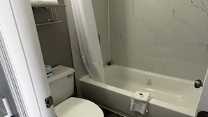 Un baño con inodoro, bañera y cortina de ducha.