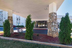 A building entrance with a covered walkway, stone pillars, and a parking lot. - 2 Queen Beds | Mobil Access Tub Nsmk Micfridg (Decatur GA)