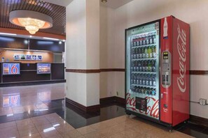 En lobby med en Coca-Cola automt, en receptionsdisk og en lysekrone.