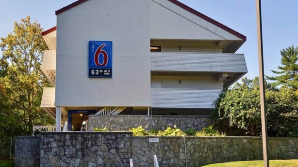 A modern building with a sign indicating a 6-star rating and Wi-Fi availability. - Cozy 2-Bed Room|Free Wifi|Vending (Nashua)