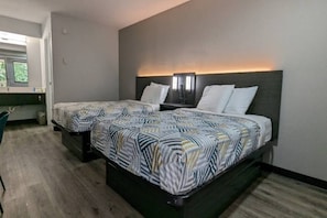 Una habitación de hotel con dos camas, un escritorio y una silla.
