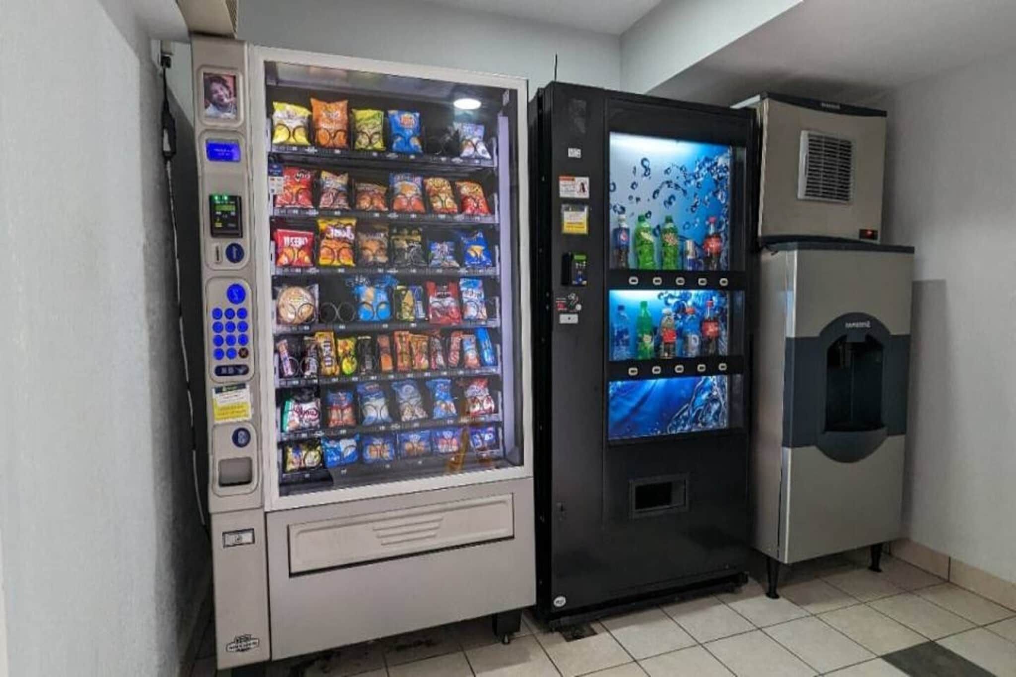 Máquina de vendas e frigorífico numa sala com chão em mosaico.