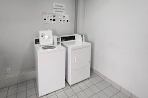 A laundry area with two washing machines and a sign indicating the motel is not responsible for unattended items.