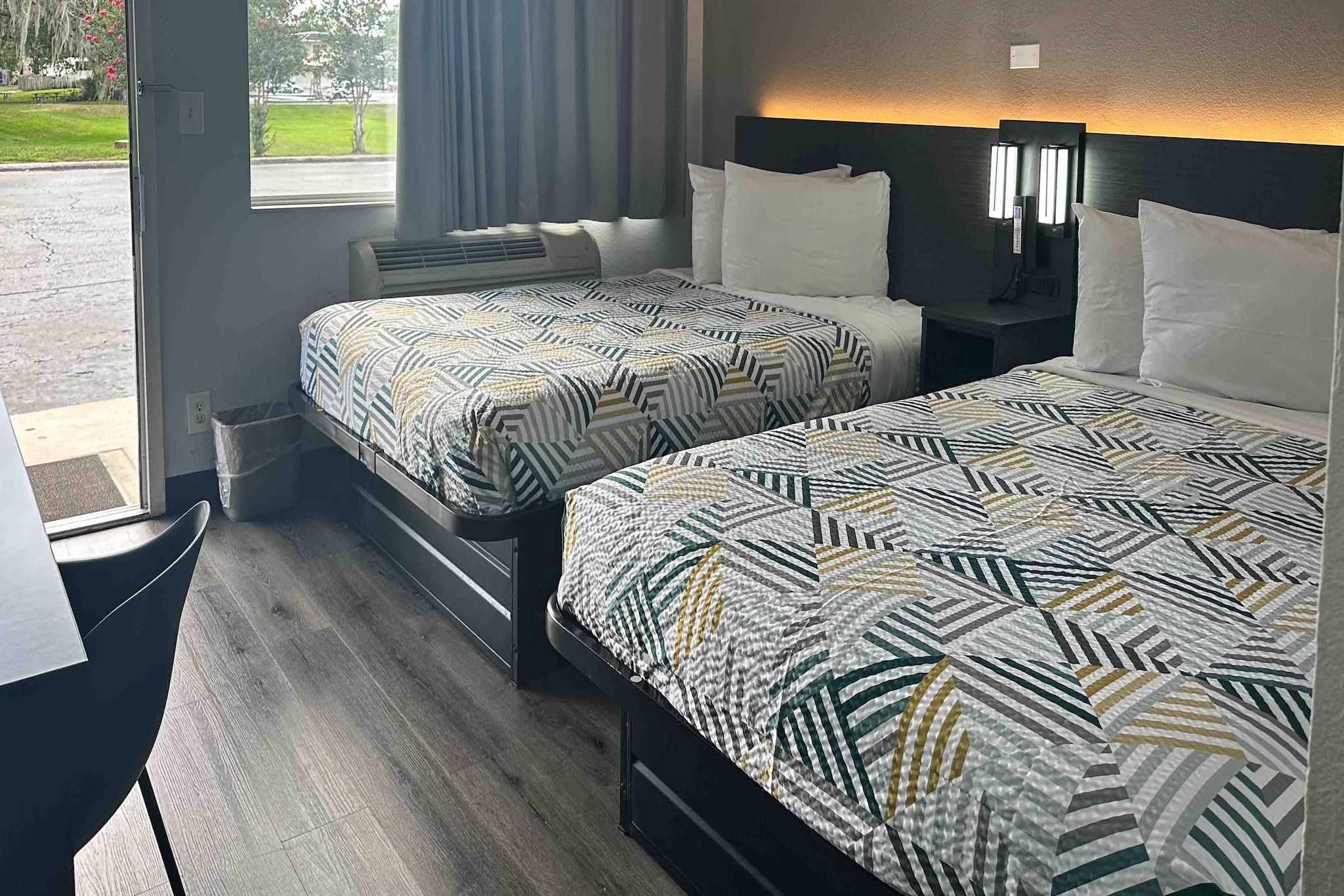 Ein Hotelzimmer mit zwei Betten, einem Schreibtisch und Blick ins Freie.