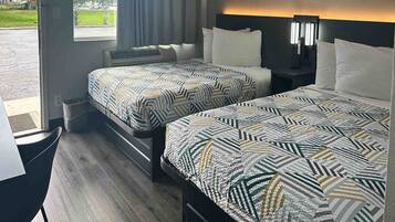 Ein Hotelzimmer mit zwei Betten, einem Schreibtisch und Blick ins Freie.