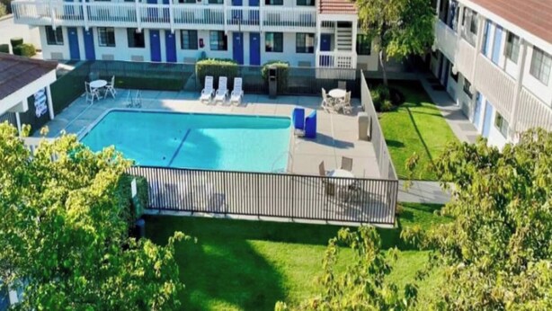 Um hotel com piscina, área de estar ao ar livre e gramado bem cuidado.