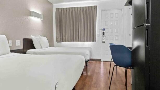 A hotel room with two beds, a desk, a chair, and a door. - 2 Queen Beds | Non-Smoking, Kitchen (San Luis Obispo)