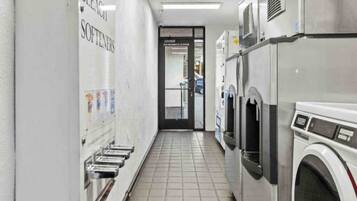 A laundry facility with multiple washing machines and a bleacher area.
