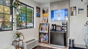 A hotel lobby with a self-service kiosk, a magazine rack, and a view of the outside through large windows. - 2 Queen Beds | Non-Smoking, Kitchen (San Luis Obispo)