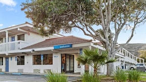 A two-story building with a 'welcome' sign, a parking lot, and a large tree in front. - 2 Queen Beds | Non-Smoking, Kitchen (San Luis Obispo)