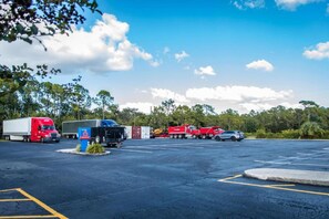 Un estacionamiento con varios camiones y una bomba de combustible.