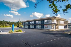 A two-story motel with a flat roof and a parking lot in front. - 2 Full Beds | Premium, Mini Fridge (Kissimmee)