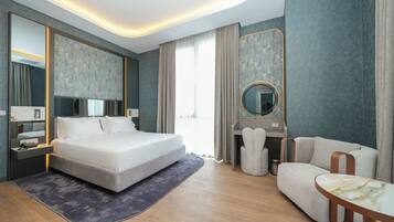 Ein modernes Hotelzimmer mit einem großen Bett, einem Schreibtisch, einem Stuhl und einem runden Tisch.