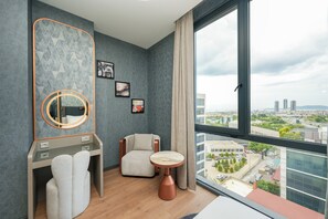 A modern hotel room with a large window, a round mirror, a vanity with a towel, a chair, and a small table. - PARK DEDEMAN KARTAL (Istanbul)