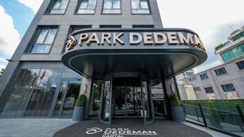 A modern hotel entrance with a curved canopy and a sign reading 'Park DedeMan Kartal'.