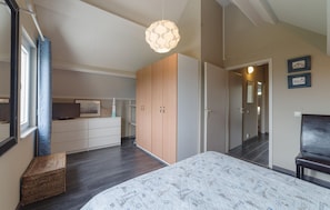 Ein Schlafzimmer mit Bett, Kleiderschrank und Fernseher.