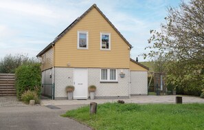 Ein zweistöckiges Haus mit Satteldach, einer Haustür und einem kleinen Vorbereich.