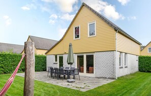A two-story house with a stone facade and a yellow exterior. - Amazing home in Wemeldinge with sauna (Wemeldinge)