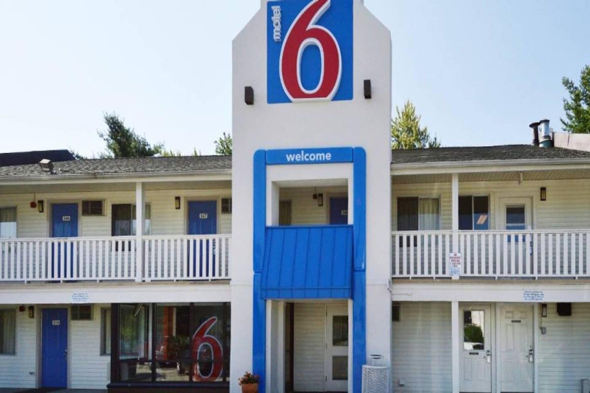 Ett motell med en framträdande skylt med siffran ”6”, en välkomnande skylt och en balkong med räcken.