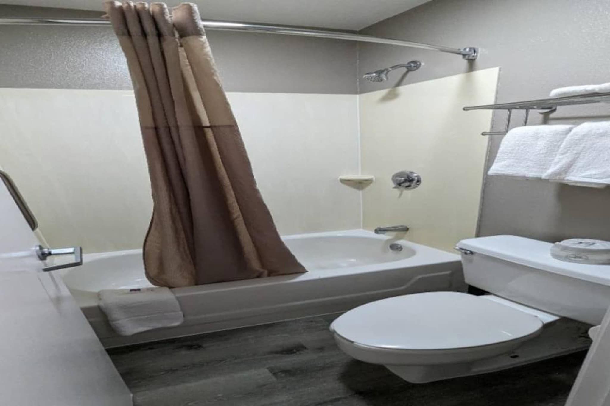A bathroom with a bathtub, toilet, and a shower curtain.