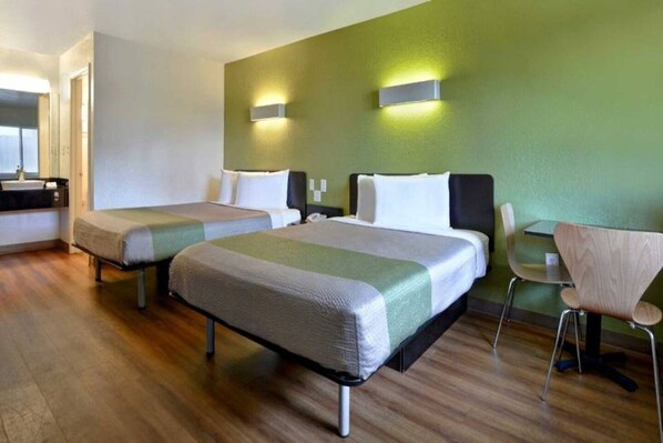 A hotel room with two beds, a desk, and a chair. - 1 Queen Bed | Extended Suite (Destin)