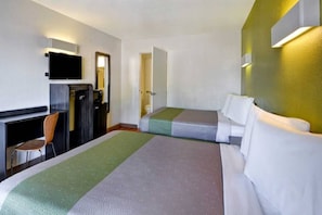 Una habitación de hotel con una cama, un escritorio, una silla y un televisor.