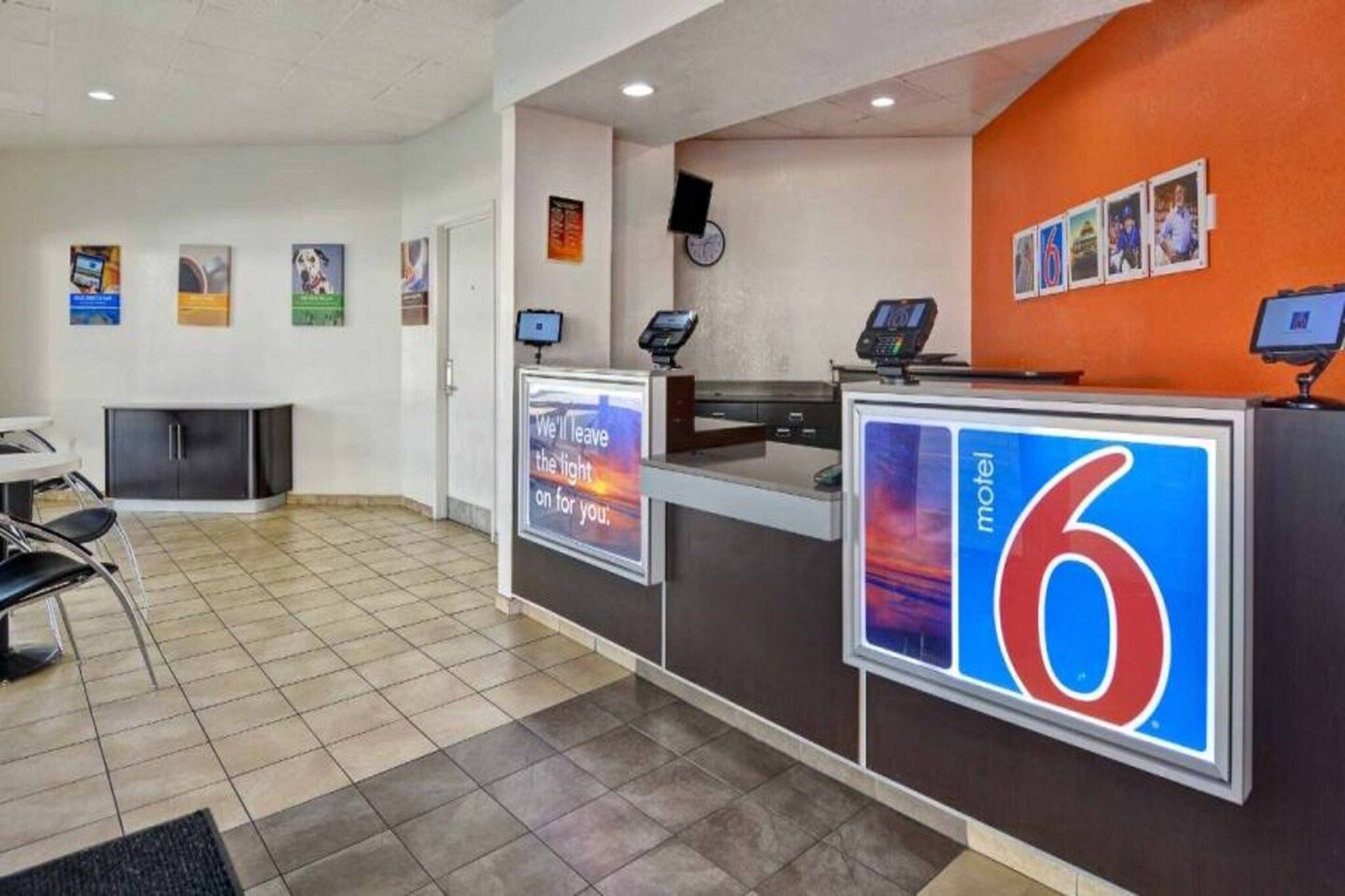 A reception desk with a digital display, a clock, and a sign for a motel.