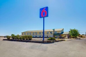 A motel with a prominent blue sign displaying the number 6. - MS6 Truth Or Consequences |1 King Bed (Truth or Consequences,NM)