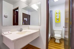 A bathroom with a white sink, a mirror, a toilet, and a shower area. - 2 Queen Beds | Non-Smoking (Truth or Consequences)