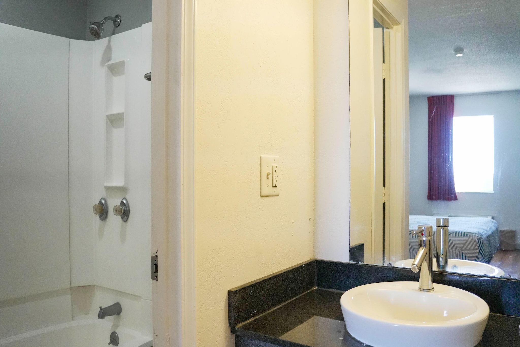 Un baño con ducha, lavabo y espejo.
