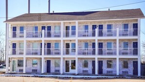 A multi-story building with a brick facade, multiple balconies, and a flat roof. - 2 Queen Beds|Nsmk,Micfridge (Rolla)