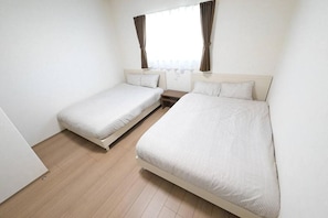 A room with two single beds, a small bedside table, and a window with curtains. - LA CHIC Stay Ozu (kikuchigun/oozumachi/muro)