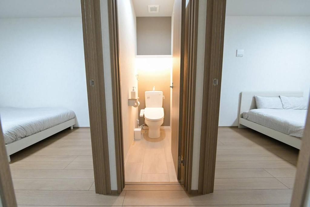 A room with a bed, a sofa, and a toilet.
