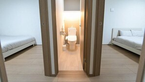 Ein Zimmer mit einem Bett, einem Schlafsofa und einer Toilette.