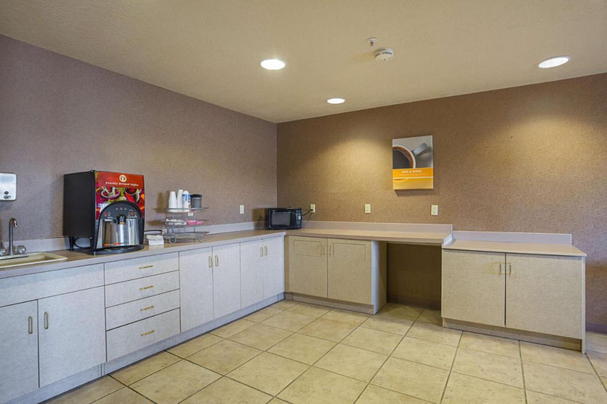 A kitchen with a coffee machine, microwave, and cabinets.