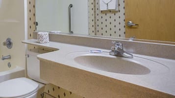 A bathroom with a sink, toilet, and mirror.