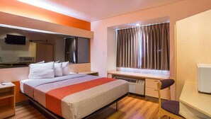 A hotel room with a bed, bedside table, desk, chair, window with curtains, and a flat-screen TV. - 1 Queen Bed | Mobility Accessible Tub Nsmk (Bernalillo)