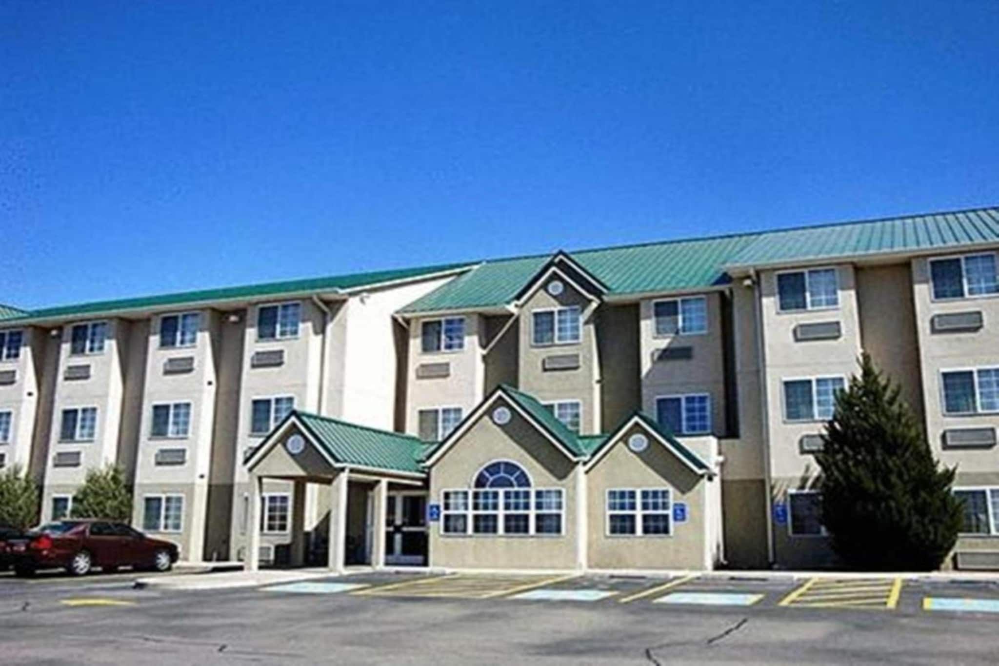 A multi-story hotel with a parking lot in front.