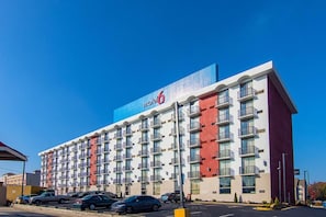 Een meerhoog hotel met een opvallend 'Motel 6' bord, met balkons en een modern architectuur.
